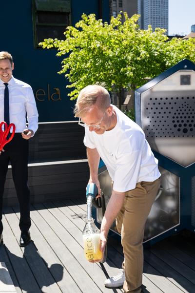 Эрик Дальгрен, соучредитель Aircela, наполняет бутылку бензином, произведенным на месте — в режиме реального времени машиной Aircela.